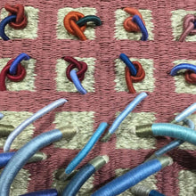 Load image into Gallery viewer, woven textile relief sculpture detail 2, vibrant playful blue and red colors on a dusty rose background
