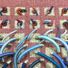 Load image into Gallery viewer, woven textile relief sculpture detail 1, vibrant playful blue and red colors on a dusty rose background
